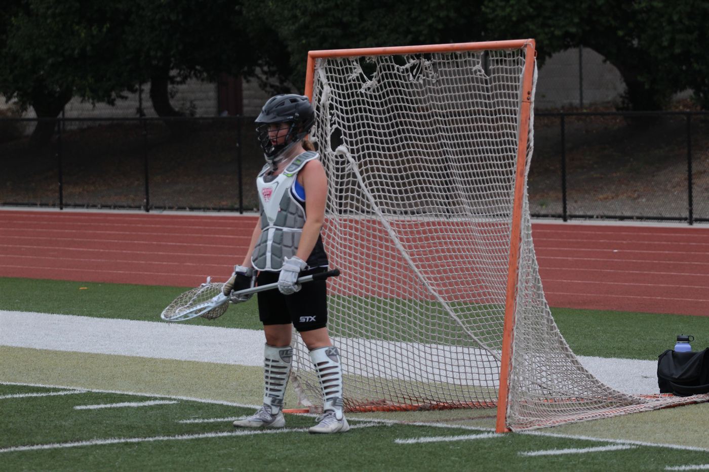A goalkeeper in full pads standing in front of the goal before a game.