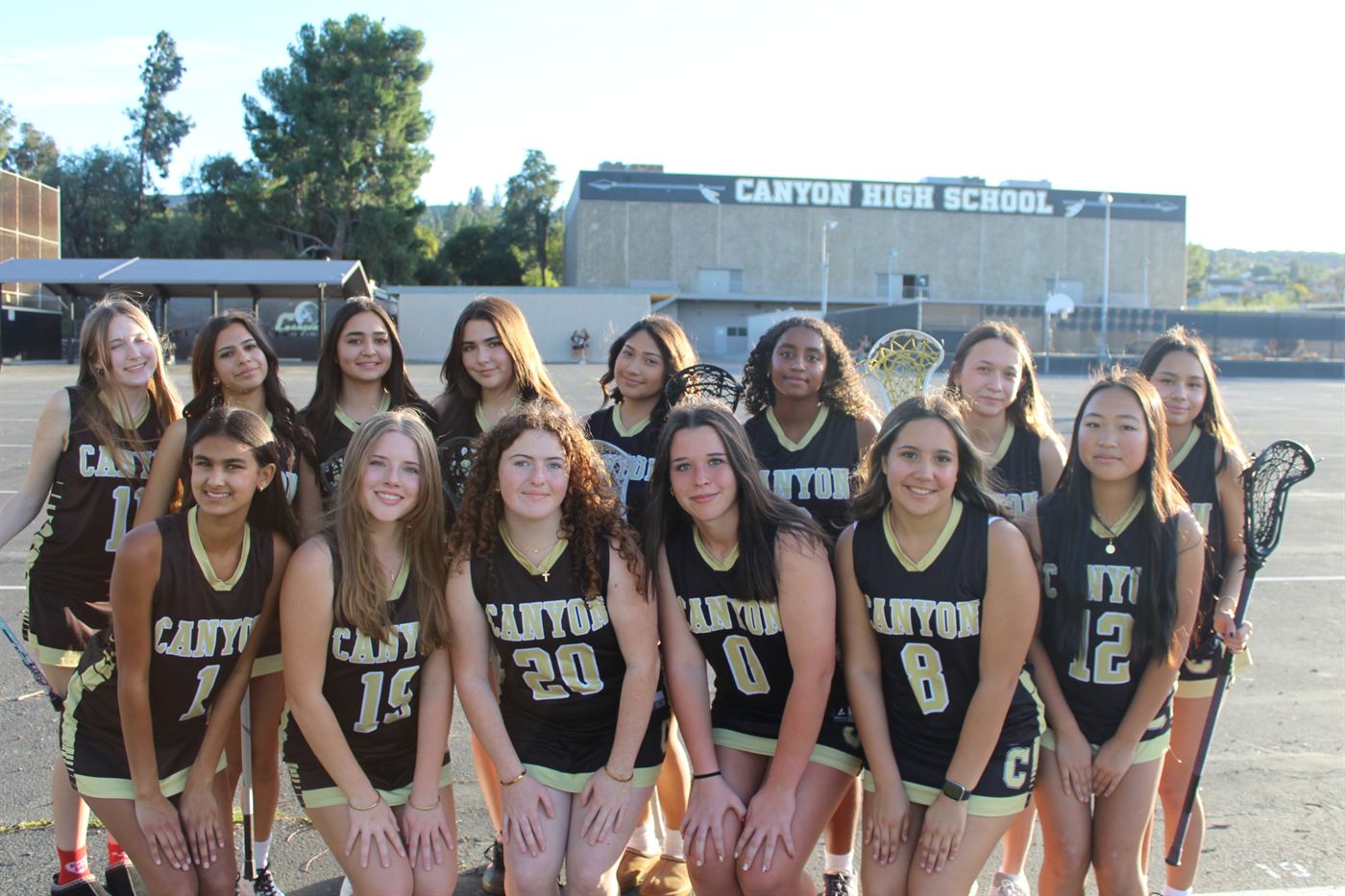 The Canyon High School girls lacrosse squad together in front of the school.